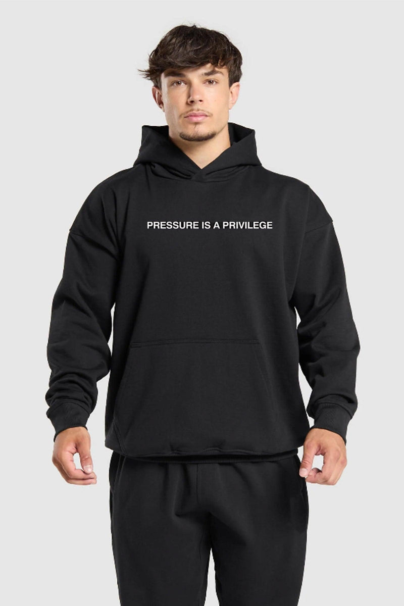 Oversized hoodie with 'Pressure is a Privilege' text, designed for comfort and style with a relaxed fit and adjustable drawstring hood.